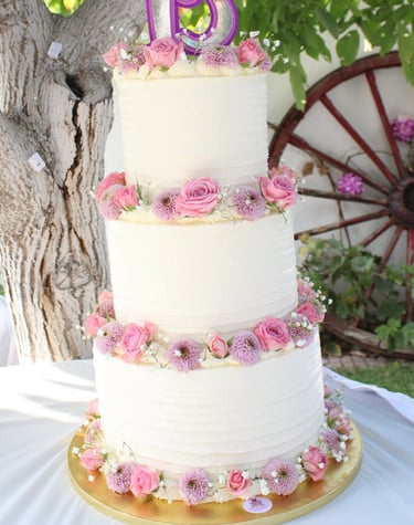 Tarta de cumpleaños elegante con flores naturales en tonos rosas, creada en Madrid