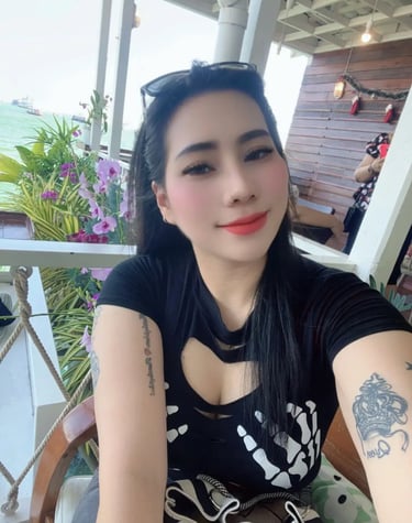 Lady wearing a black dress and tattoos showing on arms