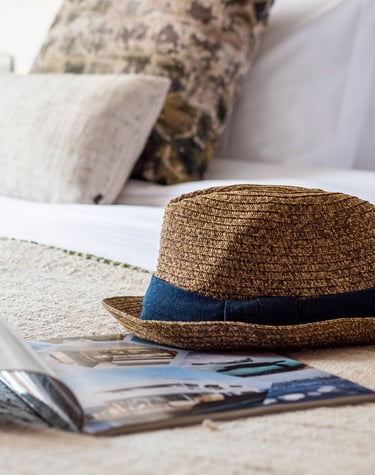 Curated luxury travel lifestyle detail with natural textures, evoking slow travel