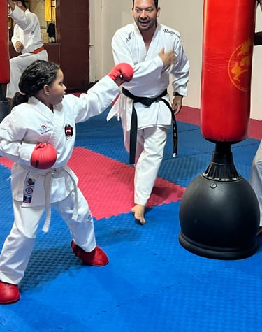 sensei adulto junto a niña atleta practicando karate movimientos de defensa personal deportiva