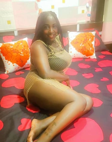 Lady wearing netted short dress and lying on a bed with red heart shaped bed sheet