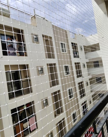 Close-up of a tightly woven safety net installed on a balcony railing.
