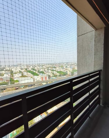 Close-up of sleek white pigeon nets installed on a sunny Whitefield balcony.