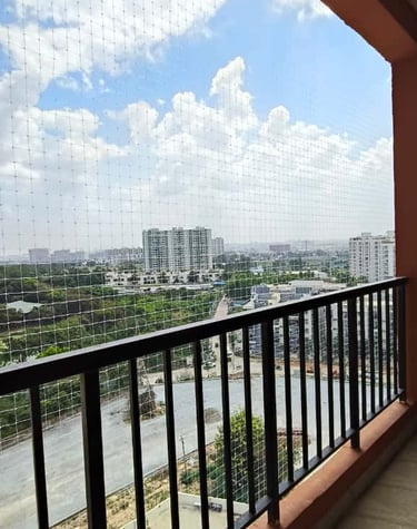 A cozy balcony secured with sturdy cat safety nets, sunlight filtering through.