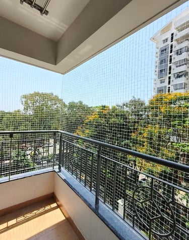Wide shot showing a balcony fully covered with a safety net against a clear blue sky.