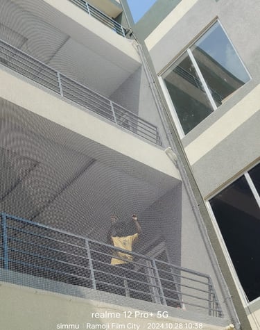 Close-up of a sturdy anti-pigeon net installed on a residential balcony in Besant Nagar.