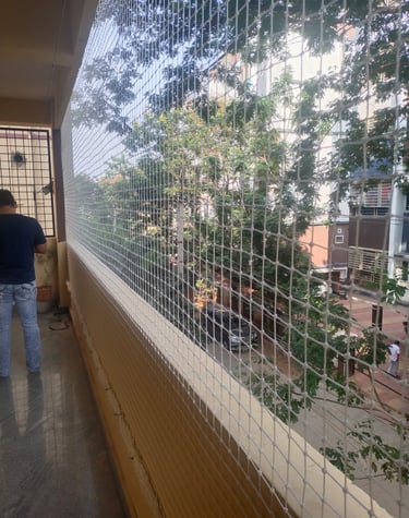 Evening view of a balcony with safety net installation glowing softly under warm lights.