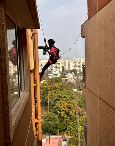 Installation team from Arjilli Enterprises fitting pigeon nets on a spacious terrace.