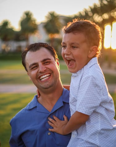 Father and son laughing together during an outdoor family photography session in Arizona.