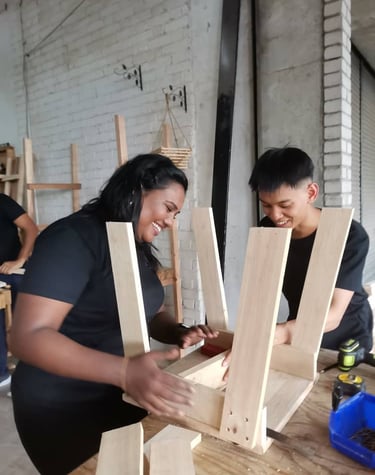 A pair working on a classroom chair which will be donated to a school after the workshop