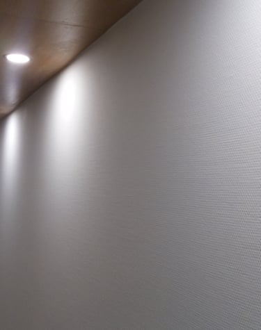 Ventanas de aluminio negro al fondo de pasillo en edificio residencial.