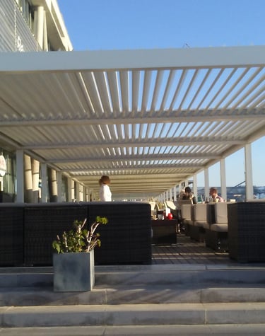 Pérgola bioclimática con mobiliario de exterior.