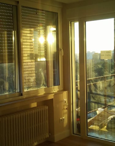 Ventanas de aluminio aislantes con luz tenue de atardecer.