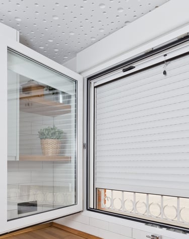 Ventana de aluminio blanca con persiana y mosquitera enrollable.