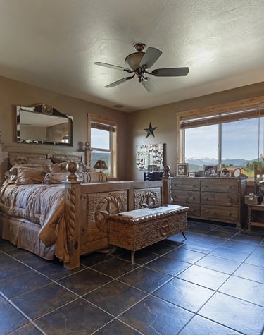 a bedroom with a bed and a dog and mountains outside