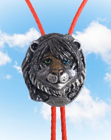 Handmade vintage style silver lion bolo tie with green and blue eyes on a red braided leather cord