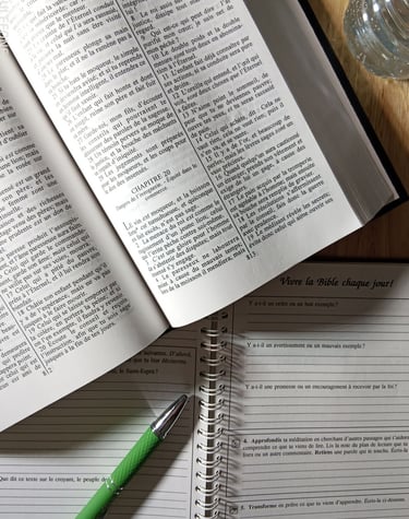 Bible Ostervald ouverte sur le proverbes 20, cahier, stylo et bouteille d'eau sur la table 