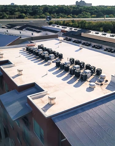 view of rooftop of building with many hvac condenser units in a row
