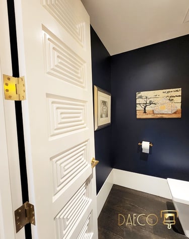 a bathroom with a white door and a blue wall