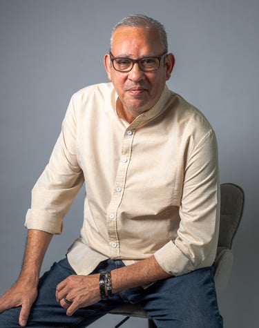 Portrait of a man in a white shirt and jeans sitting on a chair, photo studio en Jaco Costa Rica