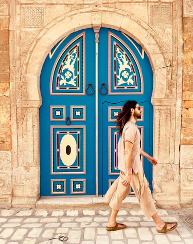 a man walking down a street in front of a blue door