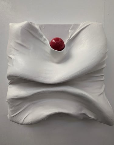 a red sphere sitting on top of plastered fabric