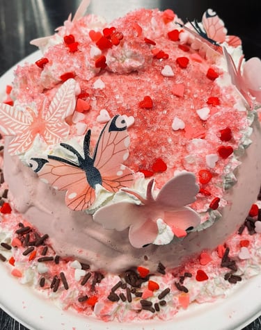 an ice cream cake with pink frosting and butterflies on it