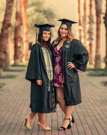 two women in graduation gowns posing for a photo