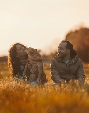 ritratto di un uomo e una donna con il cane in braccio al tramonto