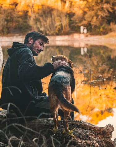 un padrone guarda in modo amorevole il proprio cane sullo sfondo di un lago