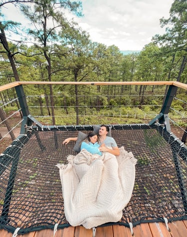 a man and woman sitting in a hammock