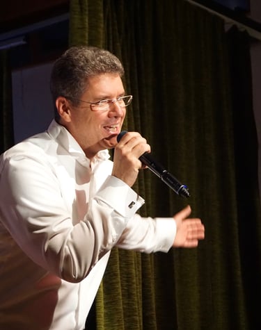 ein Mann auf der Bühne, der in ein Mikrofon singt