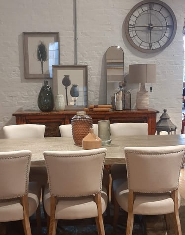 a dining room table with a clock on the wall