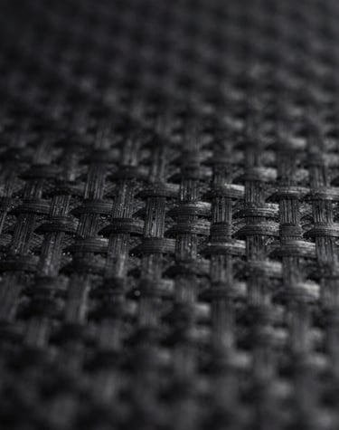 Texture-focused 8k image of dark, polished stone surface reflecting soft white light.