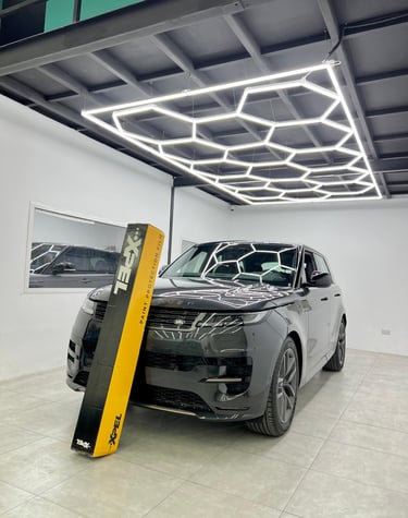 Black Land Rover Range Rover Sport with XPEL paint protection film in a professional detailing studio.