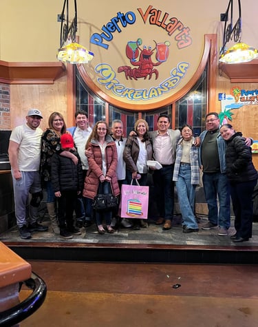 A group of friends smiling together at Puerto Vallarta Mexican restaurant for a birthday celebration.
