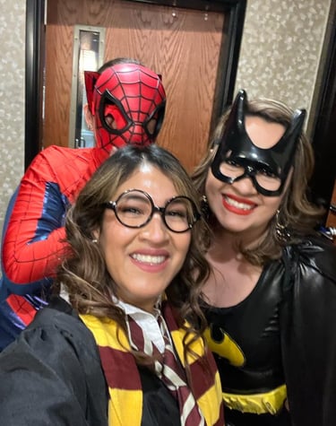 Three friends wearing Spider-Man, Batgirl, and Harry Potter costumes for a themed party or Halloween.