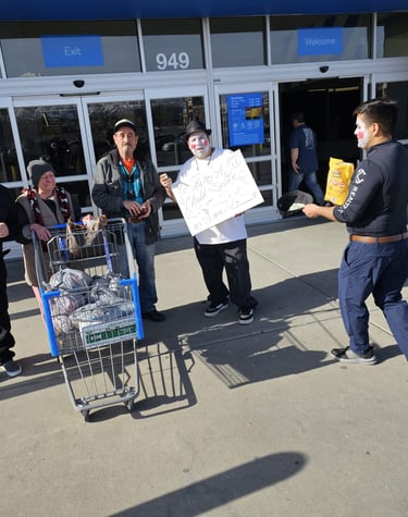 Mimes and shoppers standing with a grocery cart outside a store entrance.