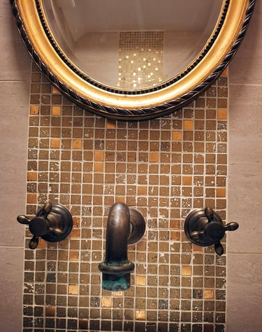 brass and bronze bathroom mirror with gold leaf mosaic tiles