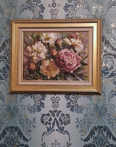 soft teal gilded wallpaper with a framed oil painting of beautiful blooms