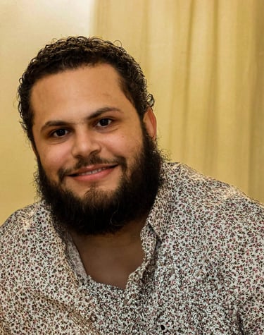Natural light portrait of a person with a clean background, showcasing a professional headshot style
