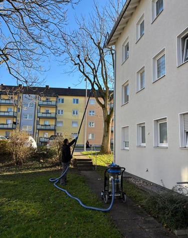 a man is using a hose to clean a lawn