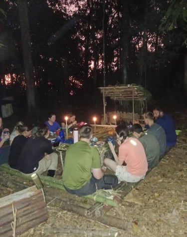 a group of people sitting around a table with candles