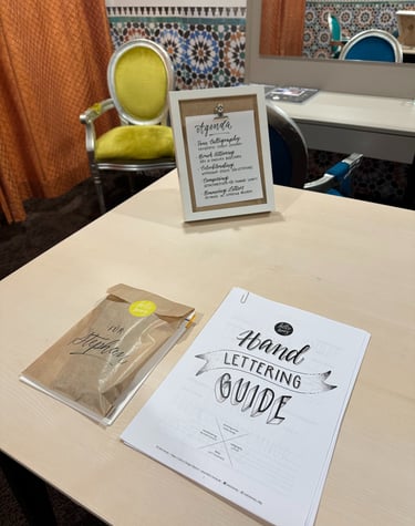 Hand lettering guide and calligraphy workshop materials on a table for a creative art class.
