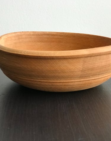 a wooden bowl with a wooden bowl on a table