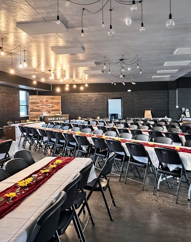 Wedding tables and chairs arranged beneath the warm brick interior of Brickyard Events, styled with 