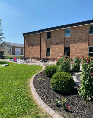 Outdoor patio at Brickyard Events with black metal tables and chairs beside a brick building under a