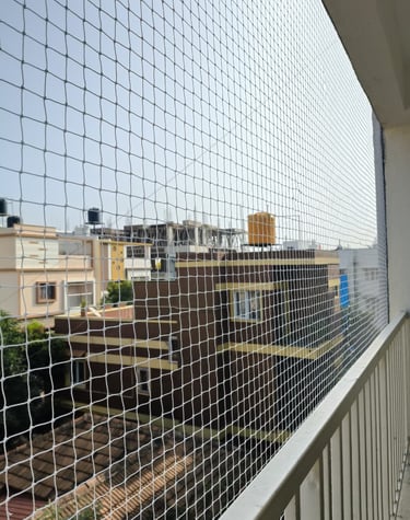 Evening photo capturing the silhouette of a balcony protected by Arjilli's pigeon nets.