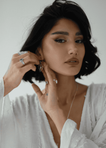 Mujer usando aretes, anillos y collares elegantes con outfit boho