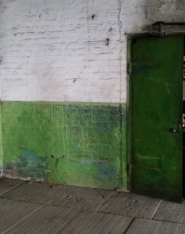 Industrial pipework, door and peeling walls located in the Stone room at Atlas Studios